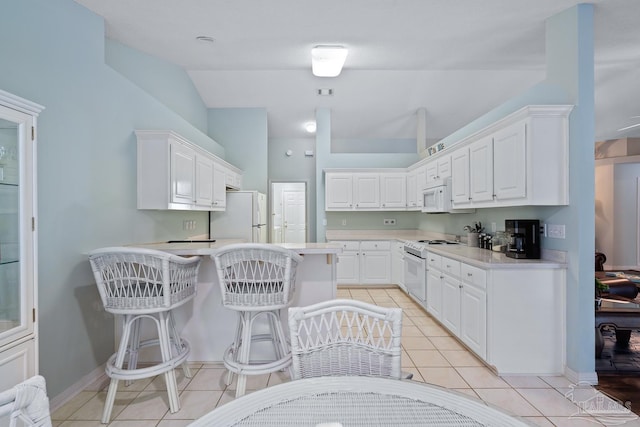 10738 Magnolia Ln, Lillian, AL 36549 - kitchen featuring white appliances, a peninsula, white cabinets, light countertops, and light tile patterned floors