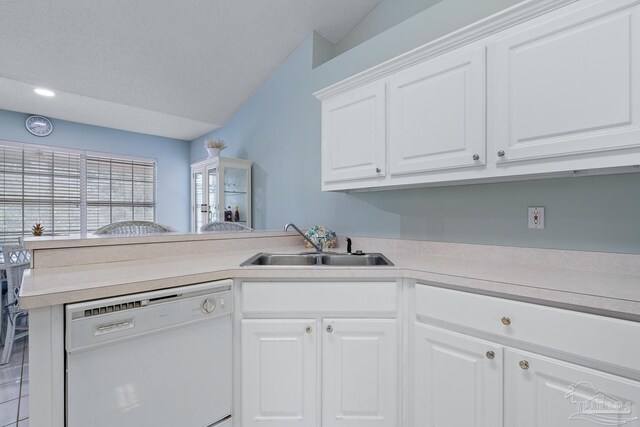 10738 Magnolia Ln, Lillian, AL 36549 - kitchen with light countertops, a peninsula, white dishwasher, white cabinets, and a sink