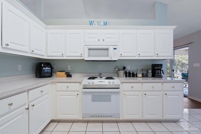 10738 Magnolia Ln, Lillian, AL 36549 - kitchen with white appliances, white cabinets, light tile patterned flooring, and light countertops