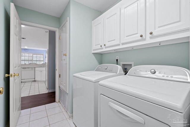 10738 Magnolia Ln, Lillian, AL 36549 - laundry room with light tile patterned floors, visible vents, cabinet space, and separate washer and dryer