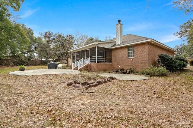 10738 Magnolia Ln, Lillian, AL 36549 - rear view of house with brick siding, fence, a chimney, a sunroom, and a patio area