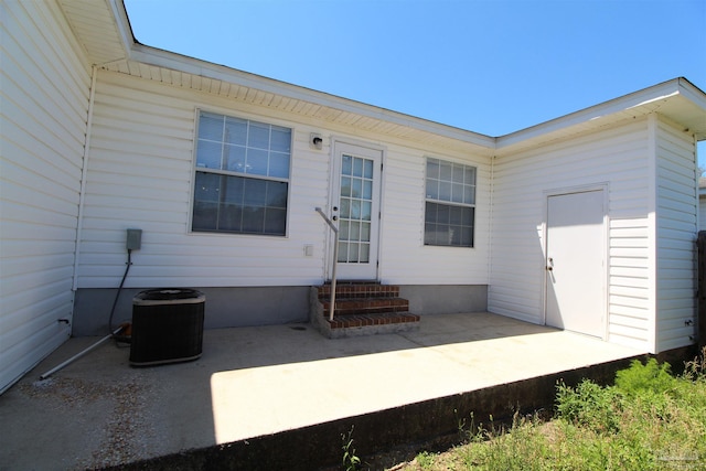 rear view of house featuring central AC unit and a patio area