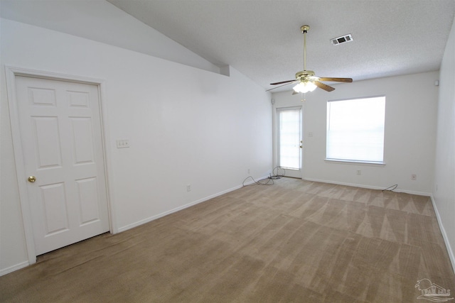 carpeted spare room with lofted ceiling, ceiling fan, and a textured ceiling