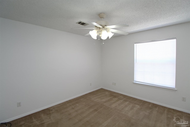 unfurnished room featuring ceiling fan, carpet floors, and a textured ceiling