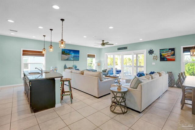 living room with ceiling fan, sink, and light tile patterned floors