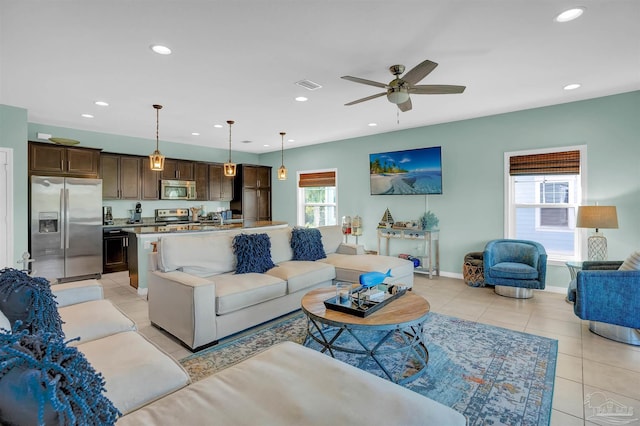 tiled living room featuring ceiling fan and plenty of natural light