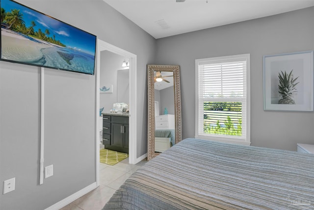 bedroom with ensuite bathroom and light tile patterned floors