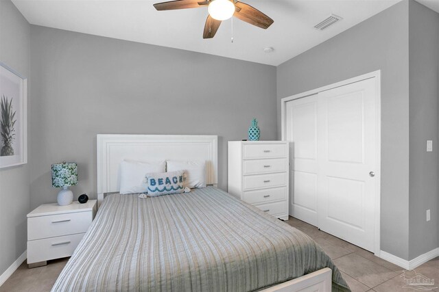 bedroom featuring a closet, light tile patterned floors, and ceiling fan