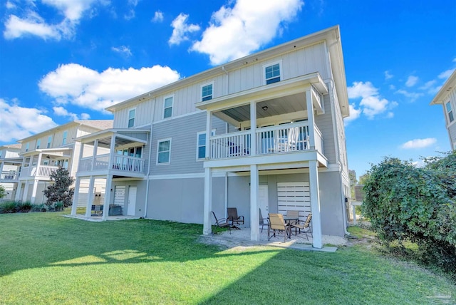 back of house with a patio area, a yard, and a balcony