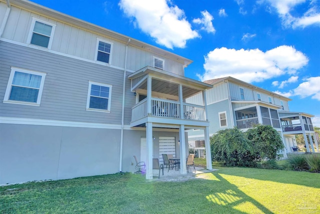 back of house with a balcony, a yard, and a patio area