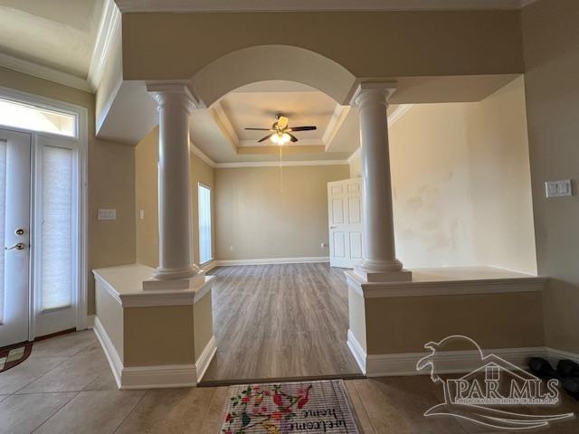 entrance foyer with decorative columns, plenty of natural light, ceiling fan, and light hardwood / wood-style floors