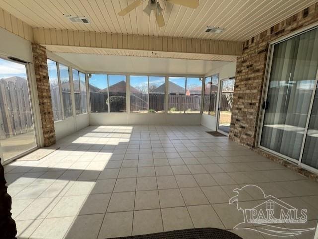 unfurnished sunroom featuring plenty of natural light, wooden ceiling, and ceiling fan