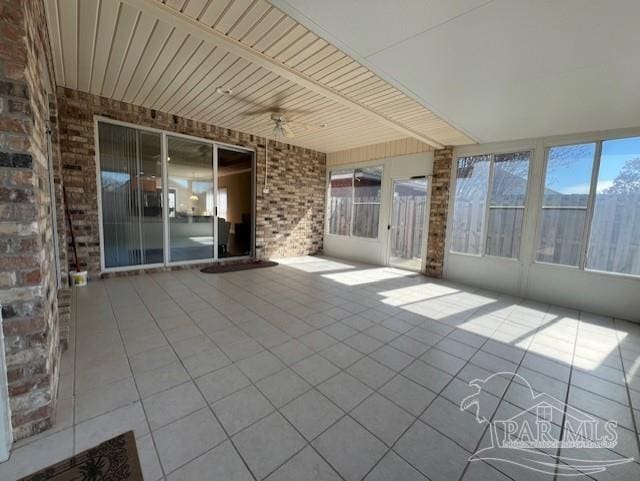 unfurnished sunroom with ceiling fan