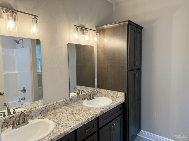 kitchen with light stone countertops, stainless steel appliances, and sink