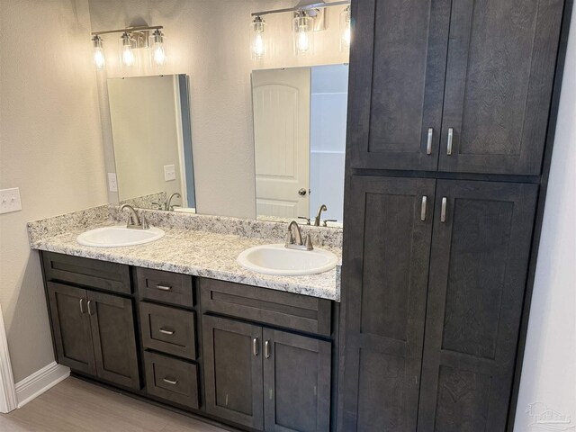 kitchen with light stone counters, sink, light hardwood / wood-style flooring, and appliances with stainless steel finishes