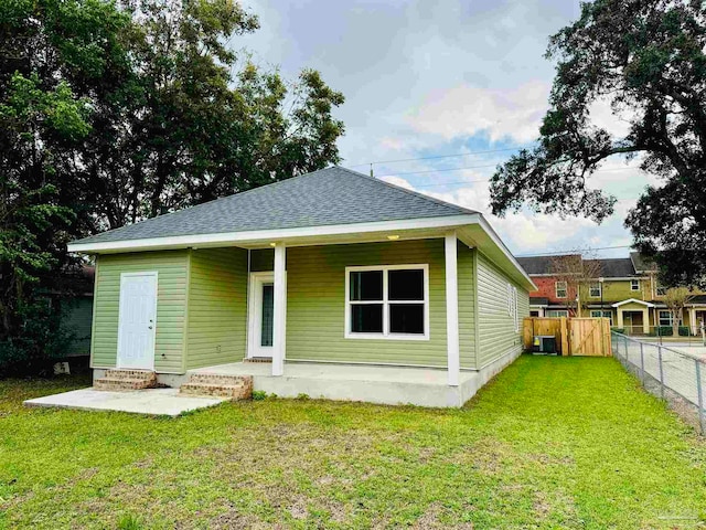 back of house with a yard and central AC