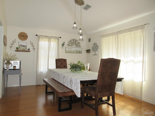 dining room featuring vaulted ceiling and hardwood / wood-style floors