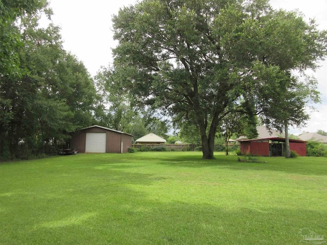 view of yard featuring a garage and an outdoor structure