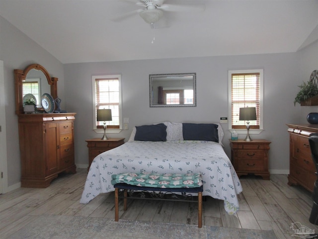 bedroom with multiple windows, vaulted ceiling, ceiling fan, and light hardwood / wood-style flooring