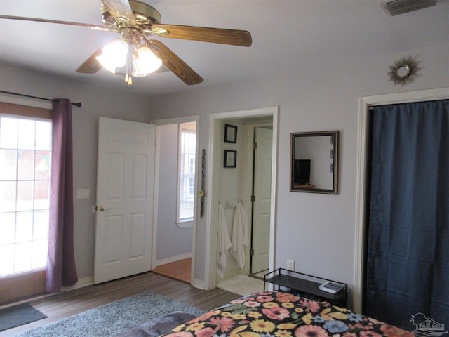 bedroom with multiple windows, ceiling fan, and light wood-type flooring