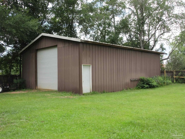 view of outbuilding with a yard and a garage