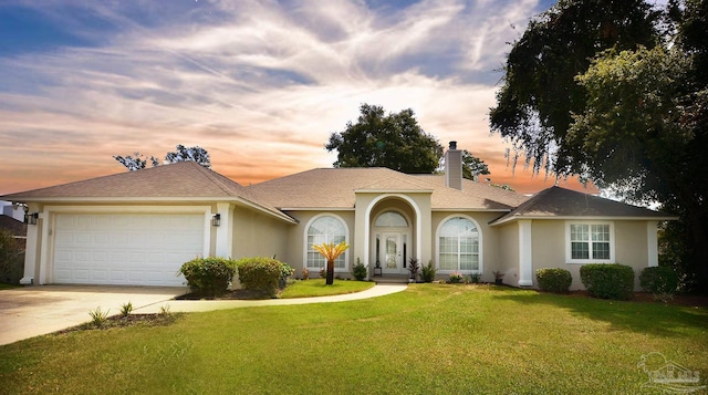 view of front of property featuring a garage and a lawn