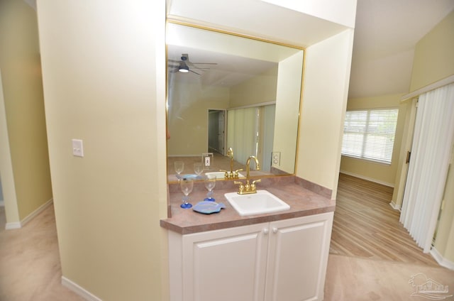 bathroom featuring lofted ceiling, wood-type flooring, vanity, and ceiling fan