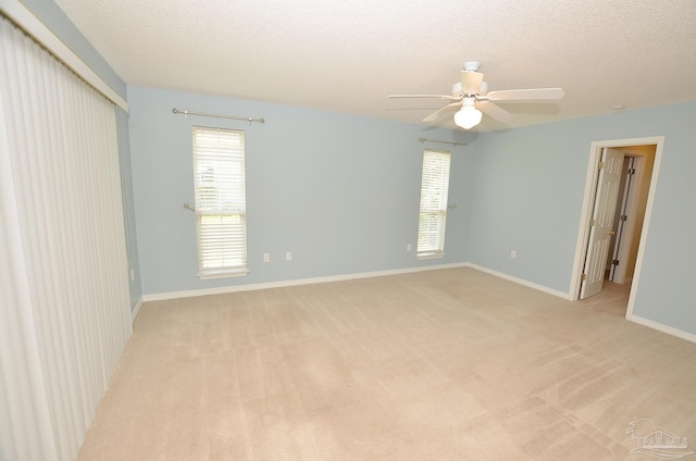 carpeted empty room featuring a textured ceiling and ceiling fan