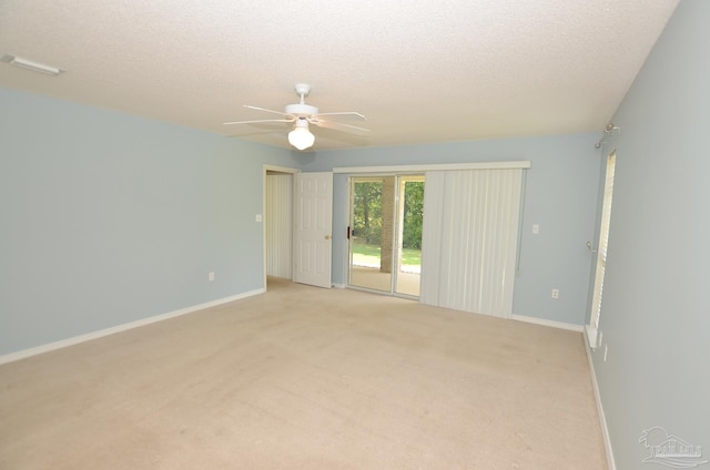 carpeted empty room with a textured ceiling and ceiling fan