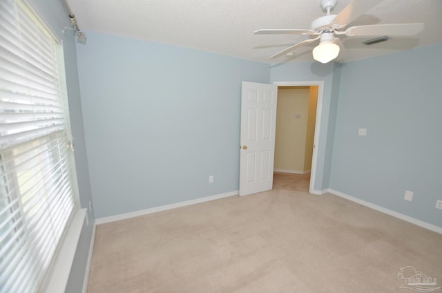 spare room with light carpet and ceiling fan