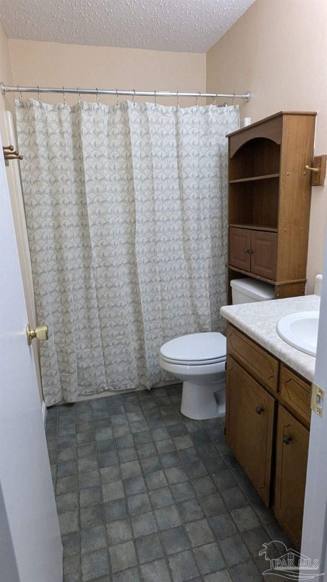 bathroom featuring vanity, a textured ceiling, and toilet