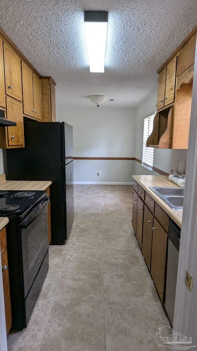 kitchen with sink, black electric range oven, exhaust hood, stainless steel dishwasher, and a textured ceiling