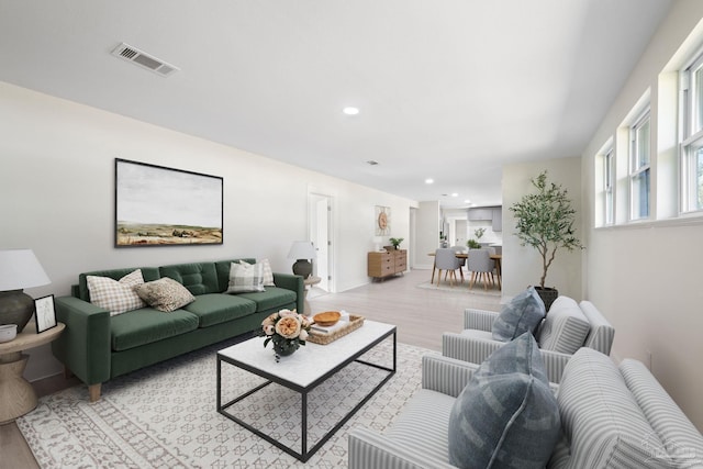 living room with light wood-style floors, visible vents, and recessed lighting