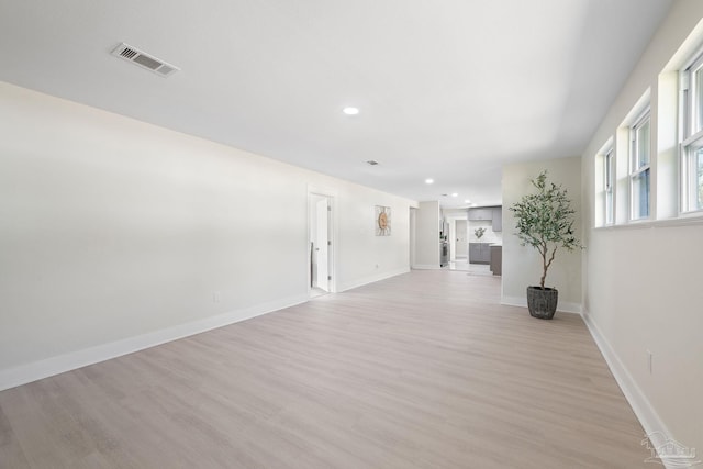 spare room featuring light wood-type flooring, baseboards, and visible vents