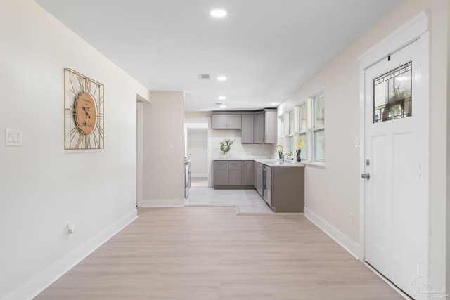 kitchen with light countertops, a sink, visible vents, and baseboards