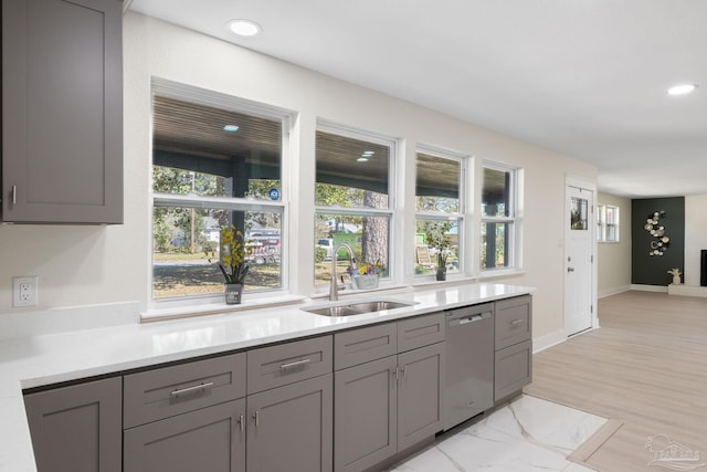 kitchen featuring recessed lighting, light countertops, gray cabinetry, a sink, and dishwasher