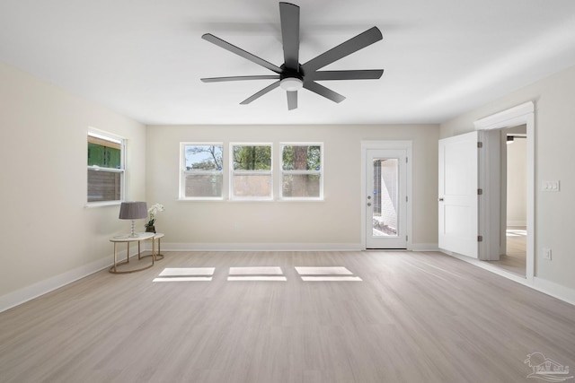 interior space with a ceiling fan, light wood-style flooring, and baseboards