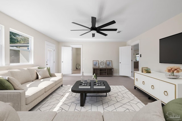 living area with visible vents, ceiling fan, and wood finished floors