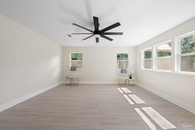 unfurnished room with baseboards, visible vents, ceiling fan, and light wood finished floors