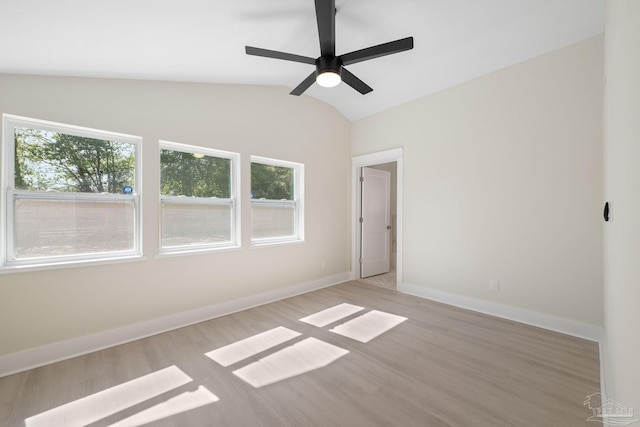 unfurnished room featuring light wood-type flooring, ceiling fan, baseboards, and vaulted ceiling