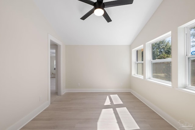 unfurnished room with light wood-type flooring, ceiling fan, baseboards, and vaulted ceiling