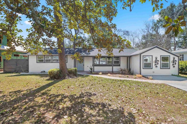 ranch-style house with a front yard, fence, and driveway