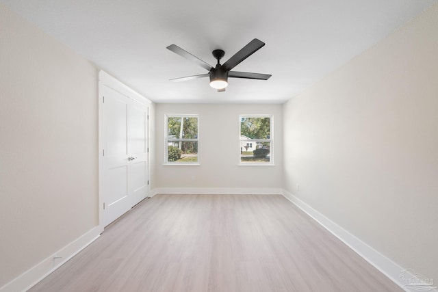 empty room featuring light wood-type flooring, ceiling fan, and baseboards