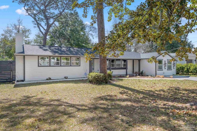 single story home featuring a chimney, fence, and a front lawn