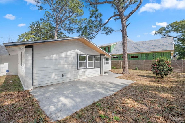 back of property with a patio area and fence