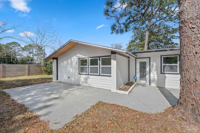 rear view of property with fence and a patio