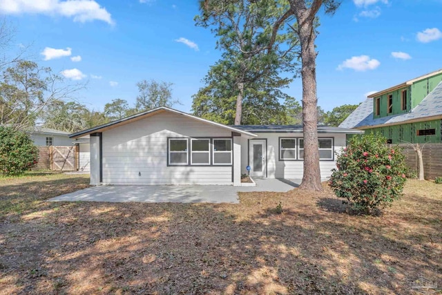 back of property featuring a gate, a patio area, and fence