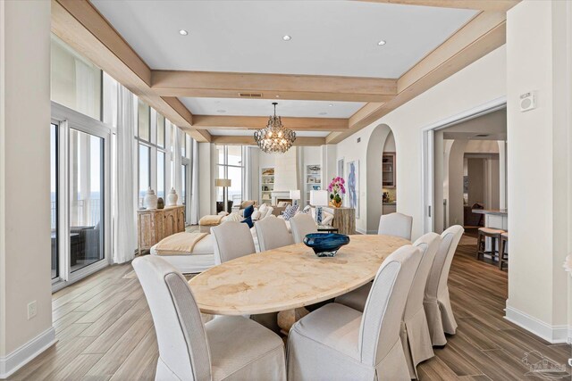 dining space featuring beamed ceiling, a chandelier, and hardwood / wood-style floors