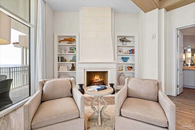 living area with hardwood / wood-style floors and a tiled fireplace