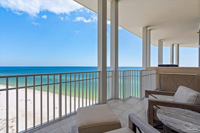 balcony featuring a view of the beach and a water view